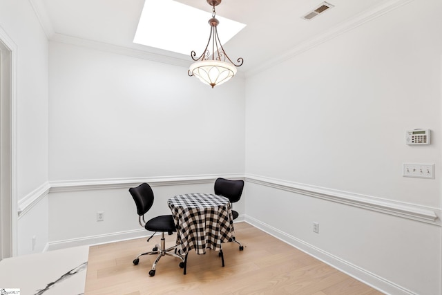 office space featuring a skylight, ornamental molding, and light wood-type flooring