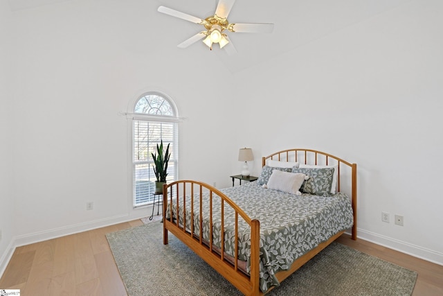 bedroom featuring ceiling fan, wood-type flooring, and high vaulted ceiling