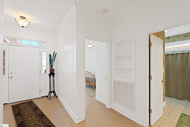 foyer entrance featuring crown molding and light hardwood / wood-style floors