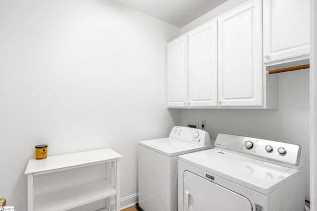 washroom featuring cabinets and washer and clothes dryer