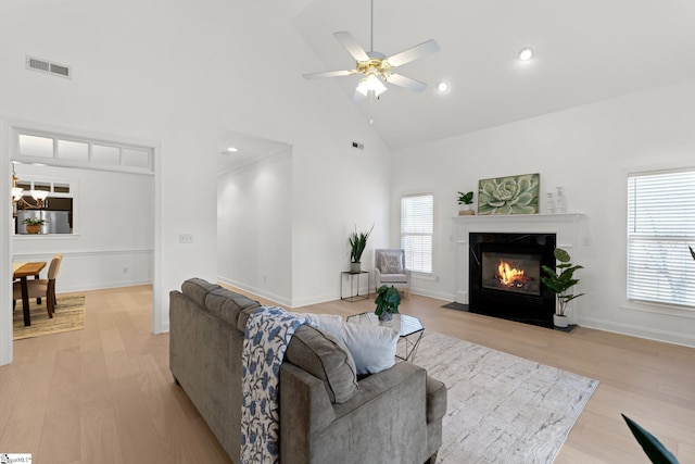 living room with high vaulted ceiling, light hardwood / wood-style floors, and ceiling fan