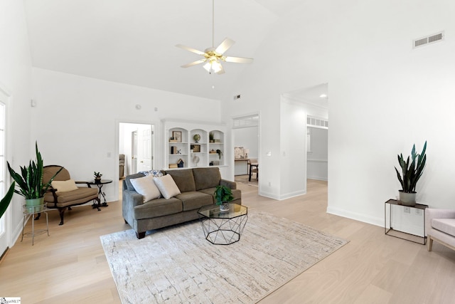 living room featuring ceiling fan, light hardwood / wood-style floors, and high vaulted ceiling