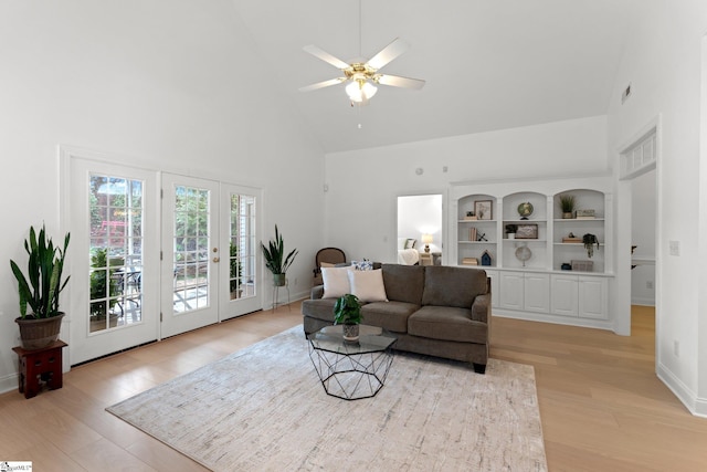 living room featuring high vaulted ceiling, light hardwood / wood-style floors, french doors, and ceiling fan