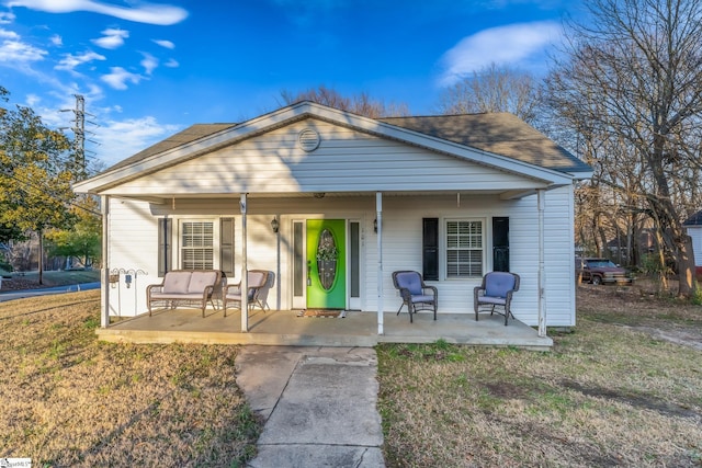 bungalow featuring a front yard and covered porch