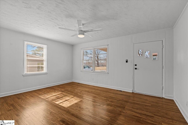 foyer with ceiling fan, a textured ceiling, and dark hardwood / wood-style flooring