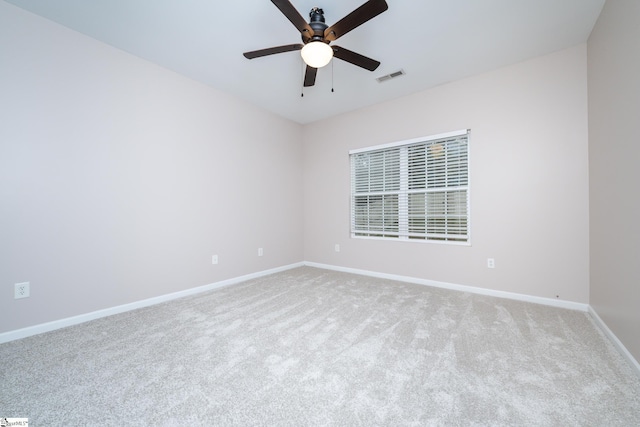 empty room featuring ceiling fan and light carpet