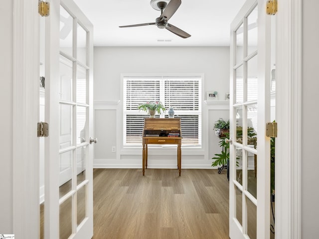 interior space with light hardwood / wood-style flooring, ceiling fan, and french doors