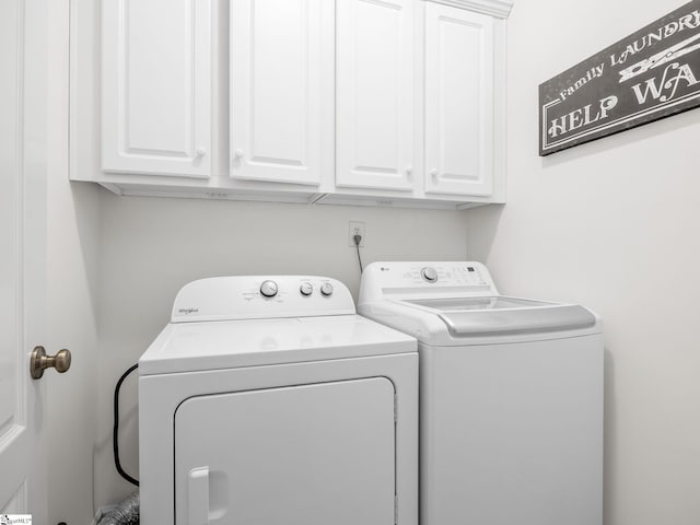 laundry room with washer and dryer and cabinets