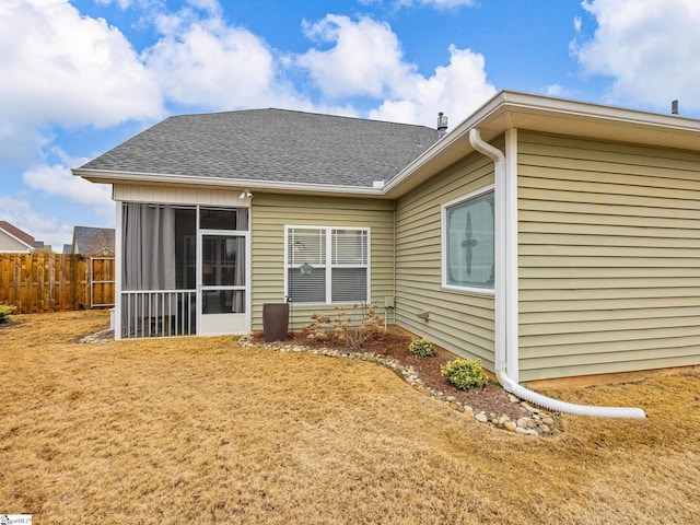 back of house featuring a sunroom and a lawn