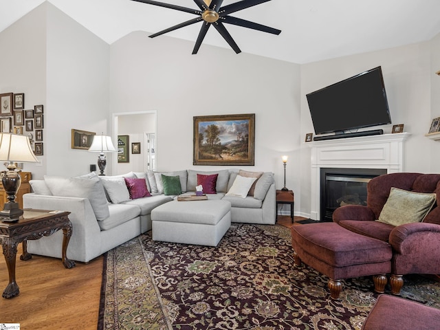 living room with hardwood / wood-style flooring, ceiling fan, and high vaulted ceiling