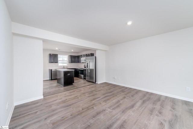 unfurnished living room with sink and light hardwood / wood-style floors