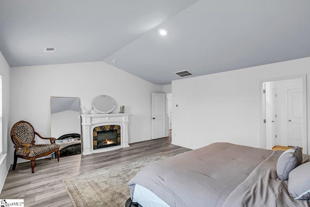 bedroom with lofted ceiling and wood-type flooring