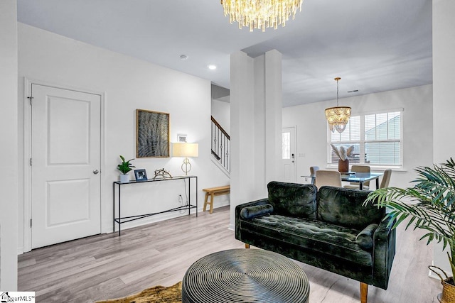 living room featuring a chandelier and light hardwood / wood-style flooring