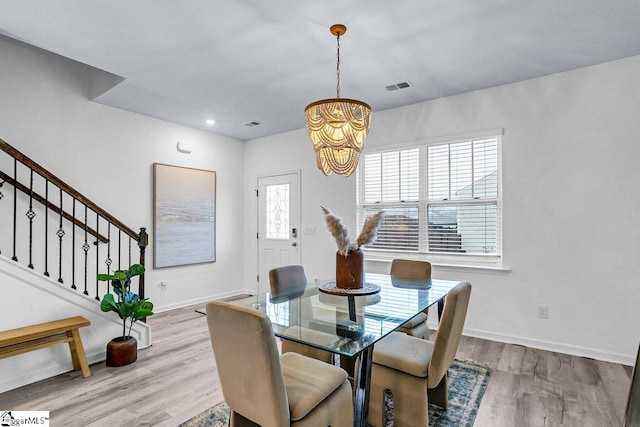 dining area with a chandelier and light hardwood / wood-style flooring