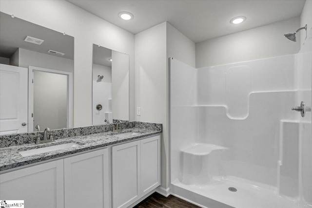 bathroom with vanity, hardwood / wood-style floors, and a shower