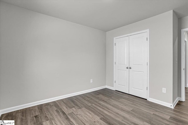 unfurnished bedroom with hardwood / wood-style floors and a closet