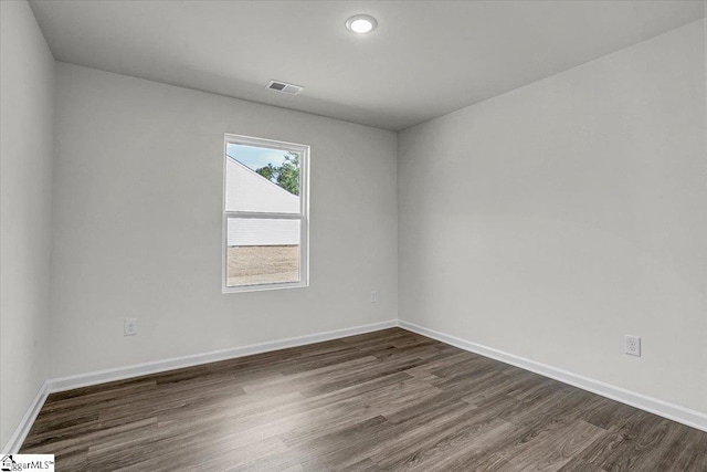 spare room with dark wood-type flooring