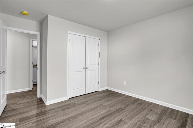 unfurnished bedroom featuring dark hardwood / wood-style flooring and a closet