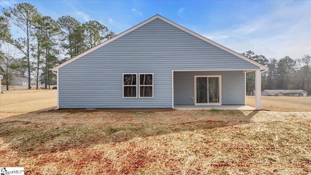 back of house featuring a patio and a yard