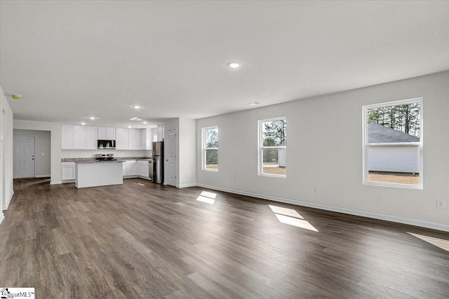 unfurnished living room with dark hardwood / wood-style flooring