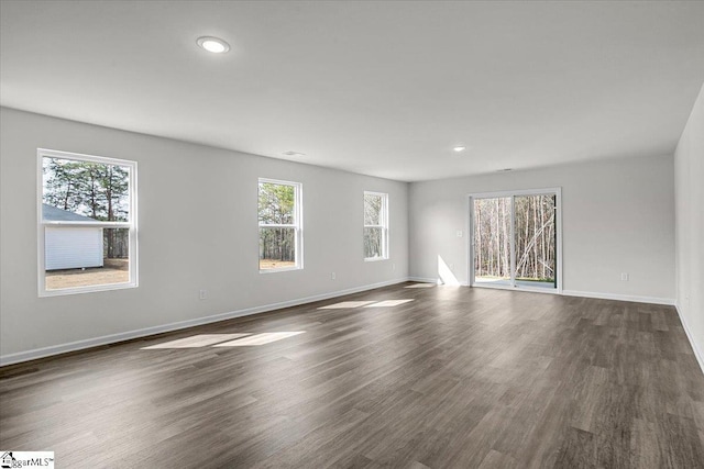 spare room featuring a wealth of natural light and dark hardwood / wood-style floors