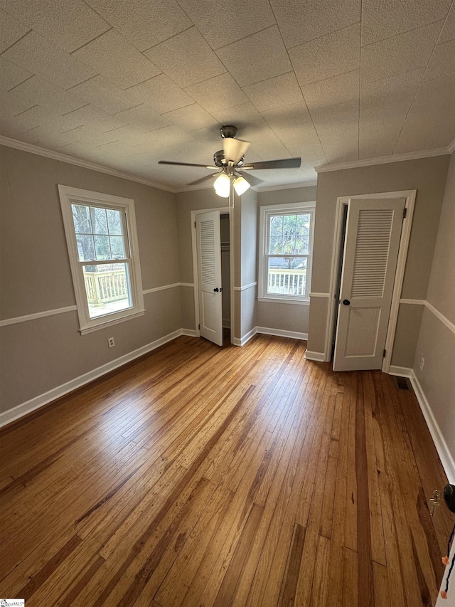 unfurnished bedroom featuring ornamental molding, ceiling fan, and light hardwood / wood-style flooring