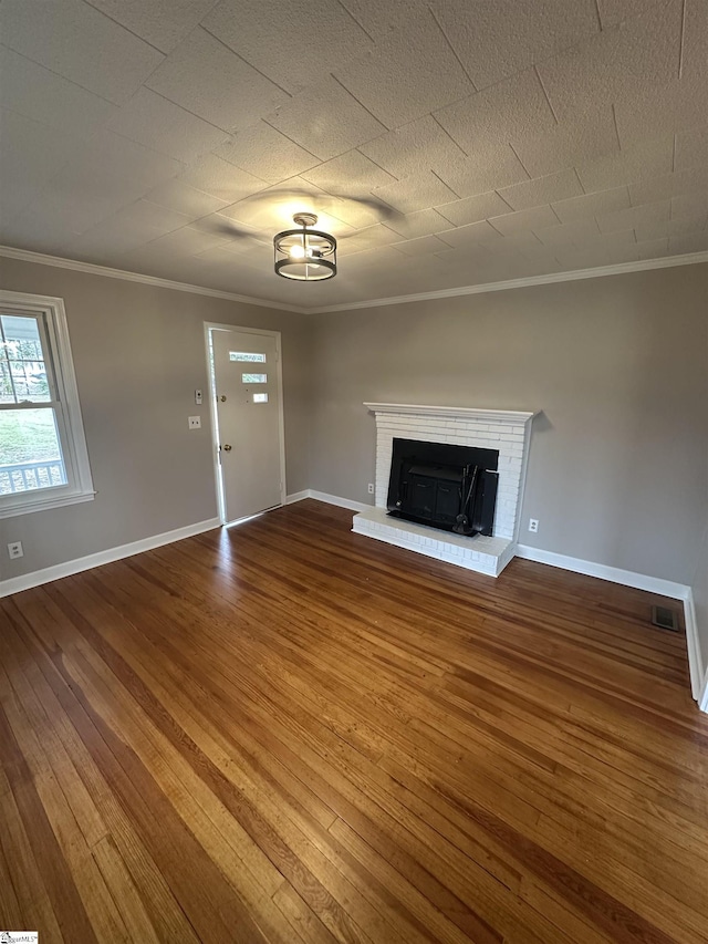 unfurnished living room featuring wood-type flooring, a fireplace, and crown molding