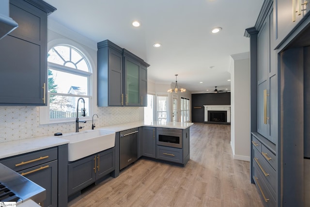 kitchen featuring appliances with stainless steel finishes, decorative light fixtures, sink, and a wealth of natural light