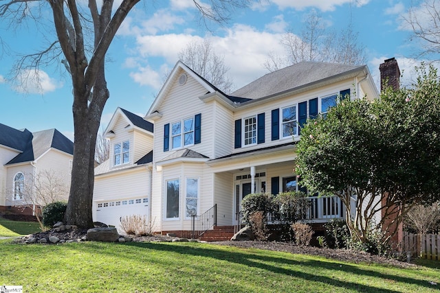 view of front of home featuring a garage, covered porch, and a front lawn