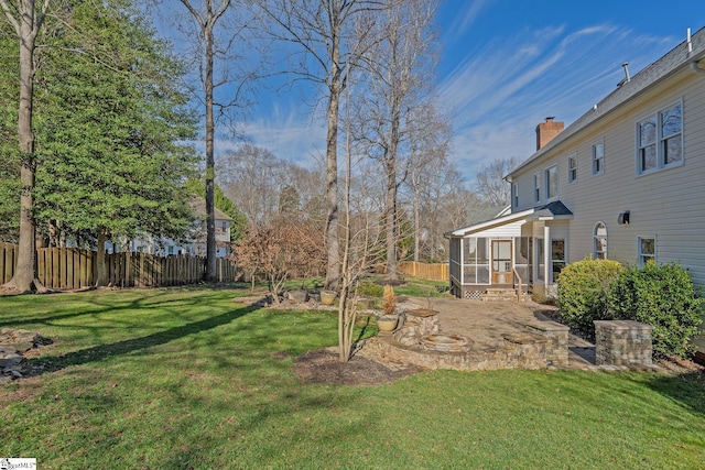 view of yard with a sunroom and an outdoor fire pit