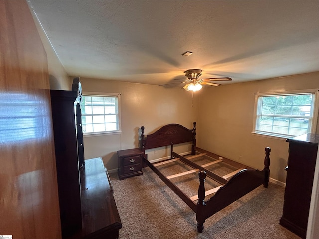 carpeted bedroom with ceiling fan and a textured ceiling