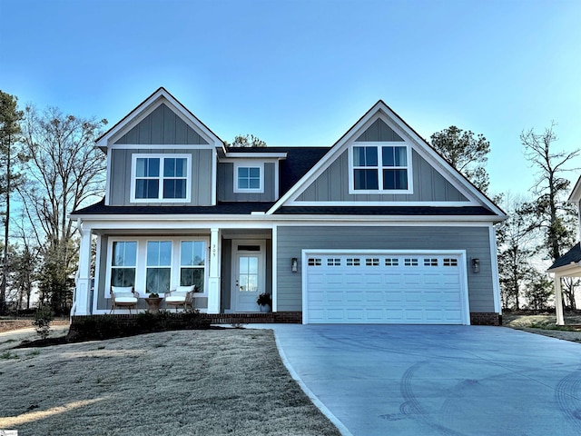 view of front facade featuring a porch, concrete driveway, and board and batten siding