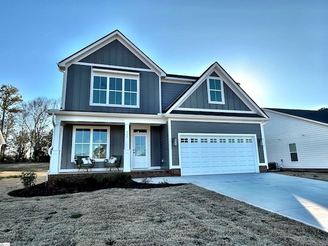 craftsman inspired home with a garage, central AC unit, and covered porch