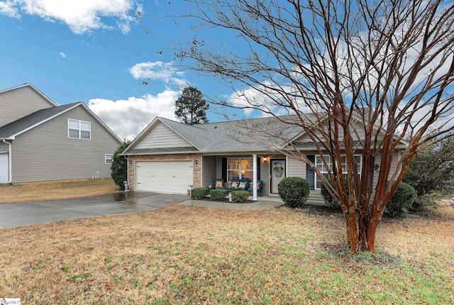 view of front facade featuring a garage, a front yard, and covered porch