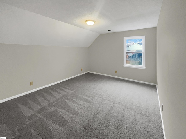 bonus room featuring vaulted ceiling, carpet floors, and a textured ceiling