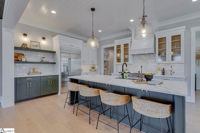 kitchen featuring white cabinetry, light hardwood / wood-style flooring, ornamental molding, stainless steel built in fridge, and pendant lighting