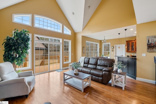 living room with bar, light hardwood / wood-style flooring, and high vaulted ceiling