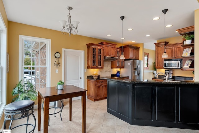 kitchen with pendant lighting, a chandelier, dark stone counters, light tile patterned floors, and stainless steel appliances