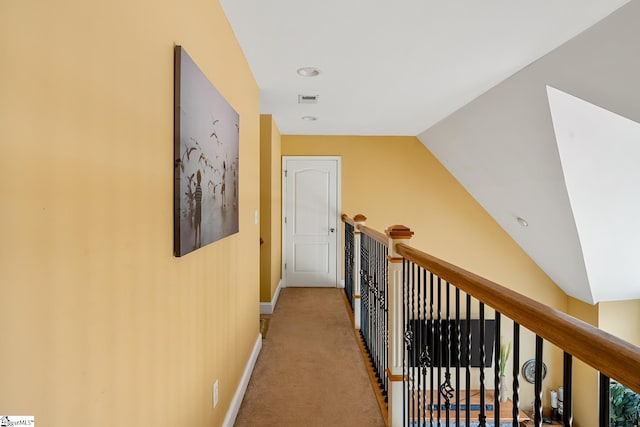 hall with vaulted ceiling and carpet