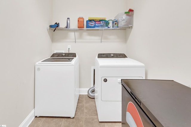 clothes washing area featuring separate washer and dryer and light tile patterned floors