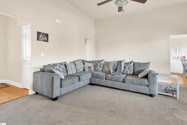 living room with carpet, a towering ceiling, and ceiling fan