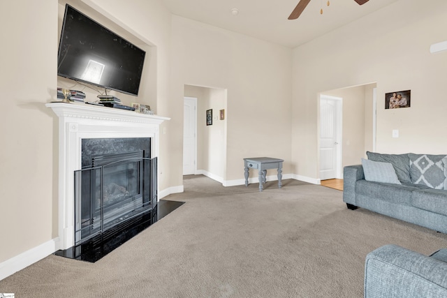 carpeted living room with a towering ceiling and ceiling fan