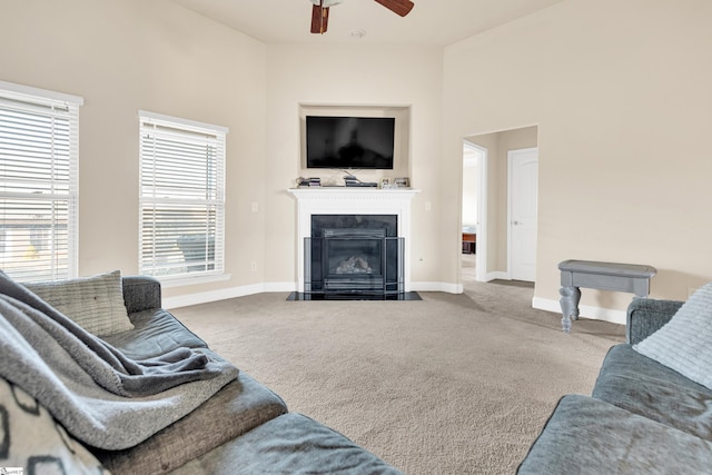 carpeted living room with ceiling fan