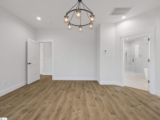 unfurnished dining area with hardwood / wood-style floors and a notable chandelier