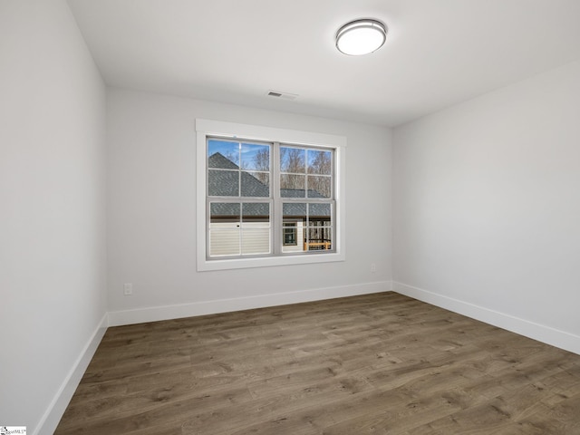 empty room with dark hardwood / wood-style flooring