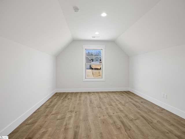 bonus room with light hardwood / wood-style floors and vaulted ceiling