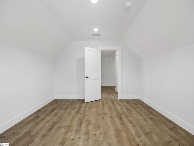 bonus room with lofted ceiling and light hardwood / wood-style floors