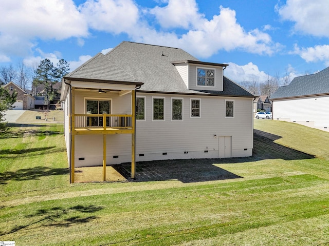 rear view of house featuring ceiling fan and a yard