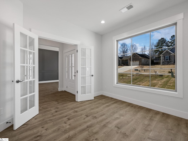 unfurnished room featuring french doors and wood-type flooring