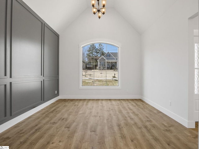 interior space featuring lofted ceiling, a notable chandelier, and light wood-type flooring